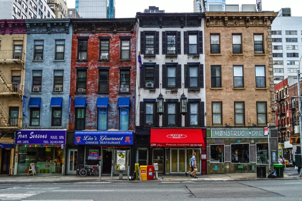 Multicolored four-story New York City buildings with storefronts on ground floor